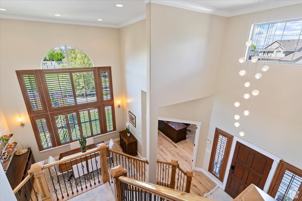 Entrance foyer featuring recessed lighting, crown molding, a towering ceiling, and wood finished floors