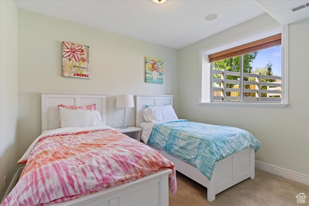 Bedroom featuring baseboards, light colored carpet, and visible vents