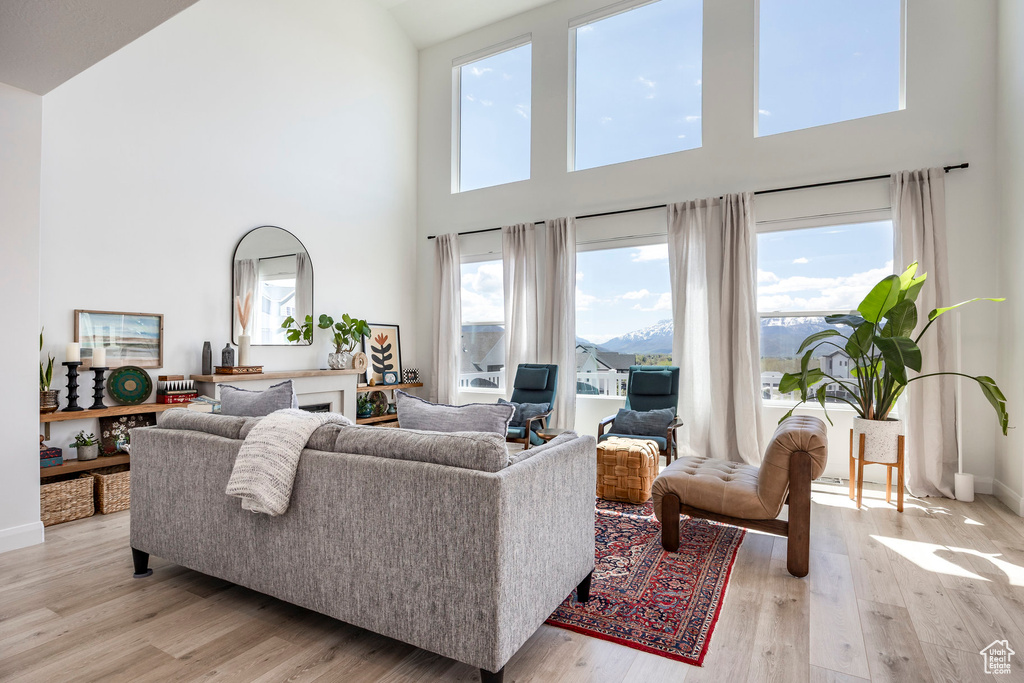Living room with high vaulted ceiling, light wood-type flooring, and baseboards