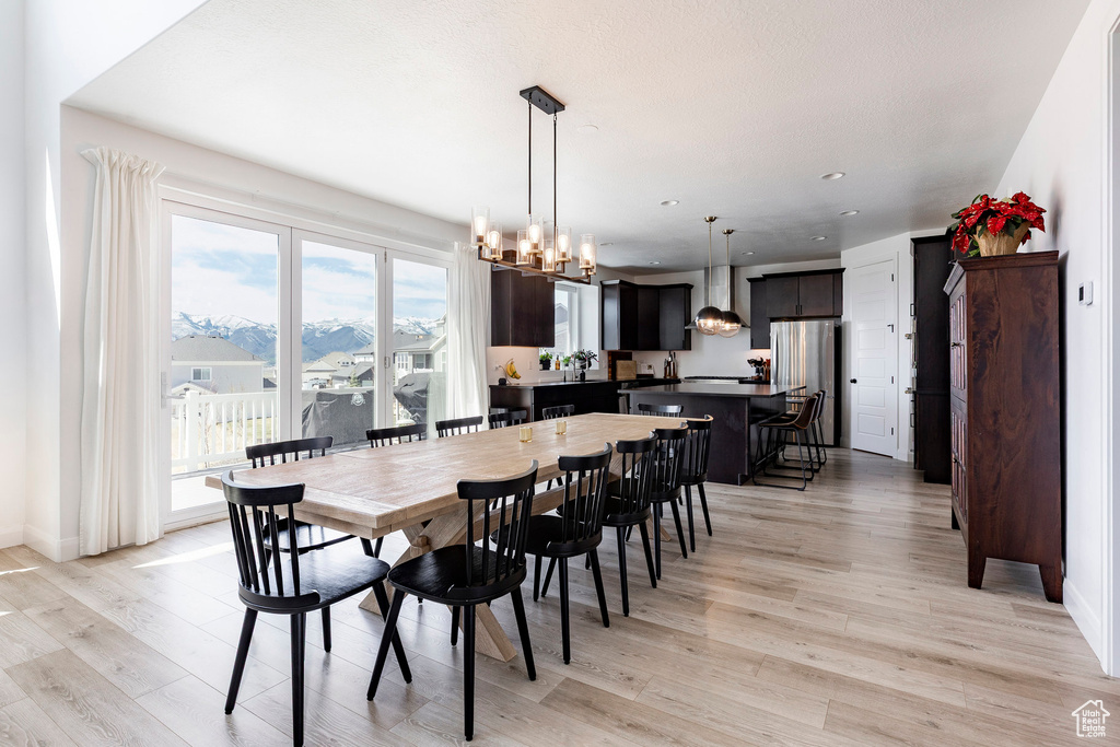 Dining area featuring light wood-style floors, recessed lighting, baseboards, and a chandelier