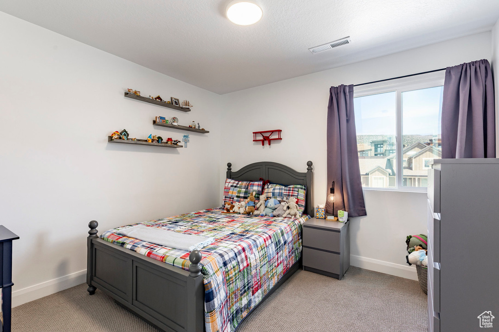 Bedroom featuring baseboards, light carpet, and visible vents