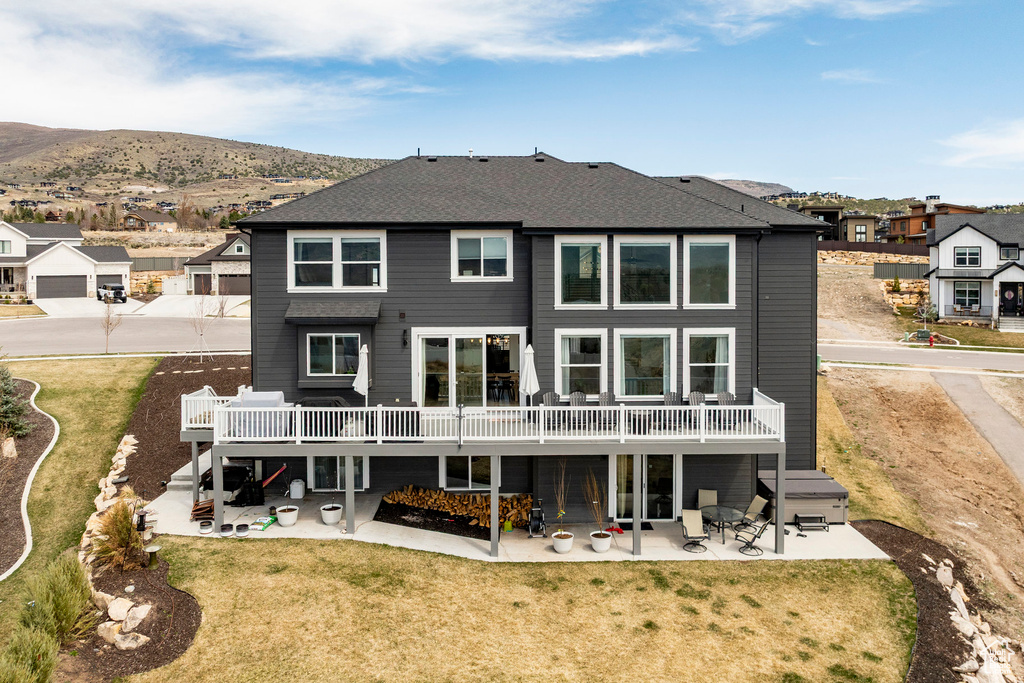 Rear view of house with a residential view, a yard, a patio, and a deck with mountain view
