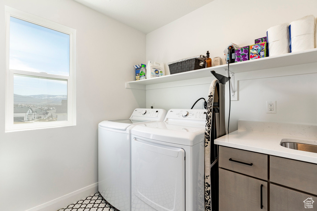 Laundry room featuring baseboards, cabinet space, and washing machine and clothes dryer