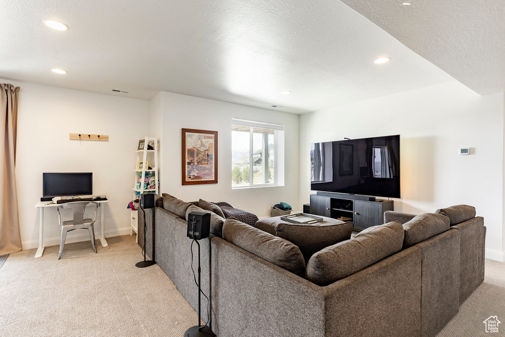 Living room with light colored carpet, recessed lighting, and baseboards
