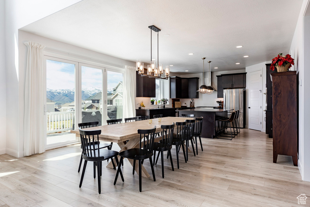 Dining room featuring light wood-style floors, recessed lighting, and a notable chandelier