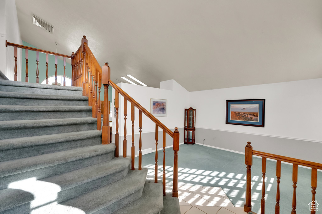 Stairs featuring baseboards and lofted ceiling