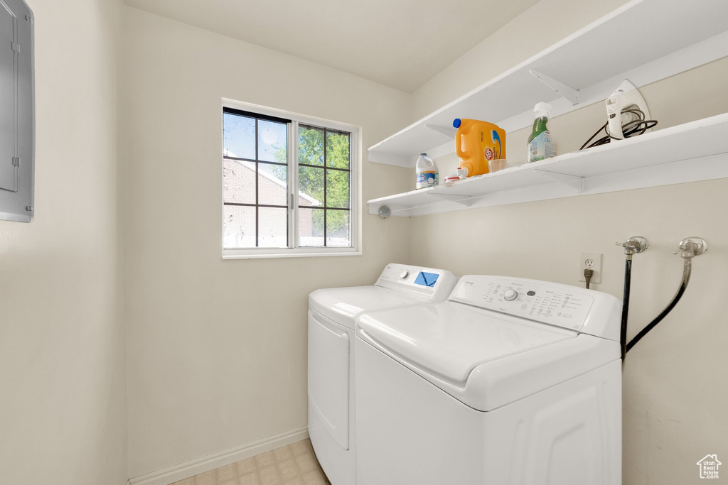 Clothes washing area with laundry area, baseboards, light floors, and washing machine and clothes dryer