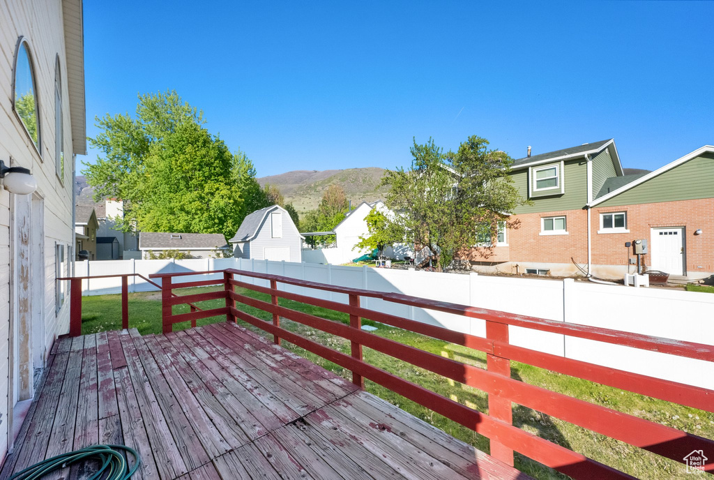 Deck featuring a fenced backyard, a mountain view, a yard, and a residential view