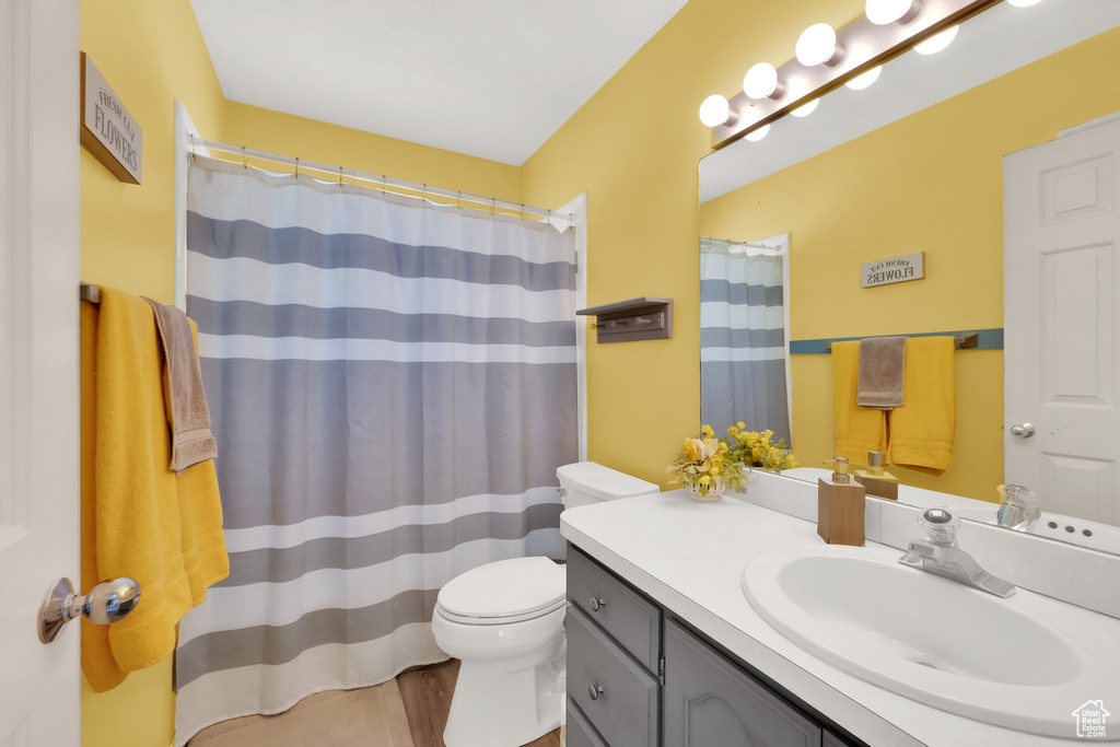 Full bath with toilet, a shower with shower curtain, and vanity