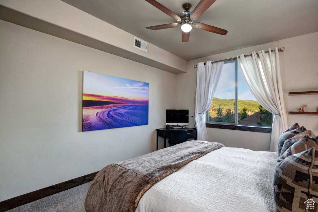 Carpeted bedroom with baseboards and ceiling fan