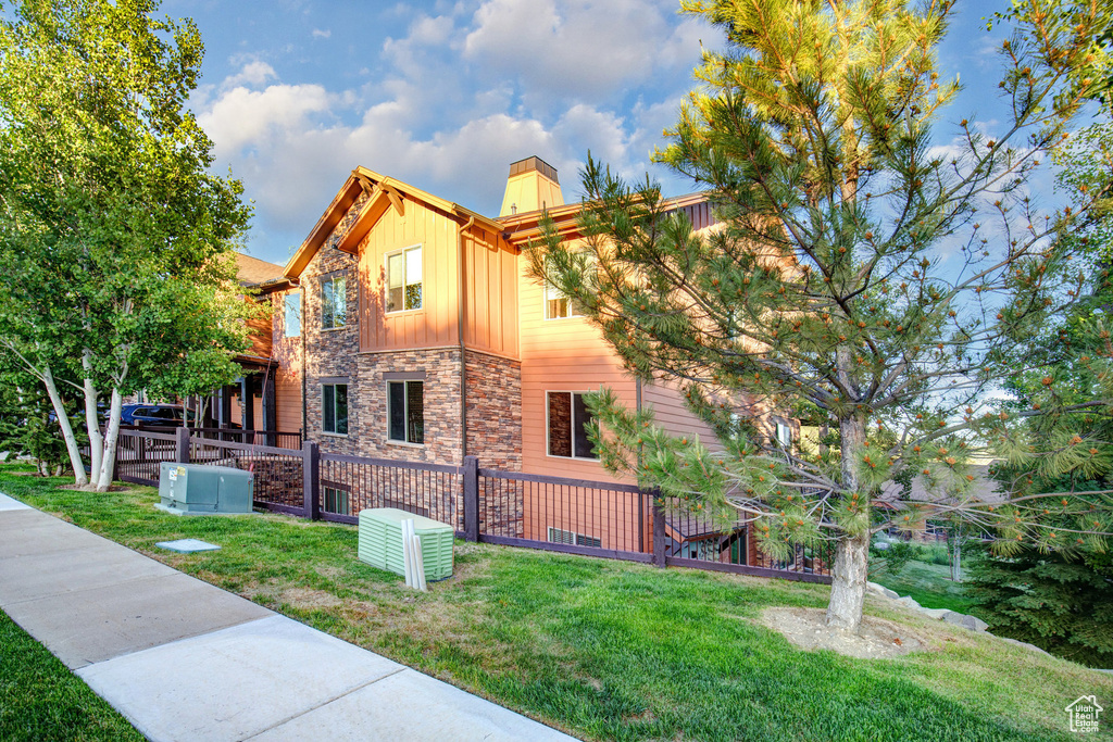 View of home\'s exterior featuring board and batten siding, stone siding, and a chimney
