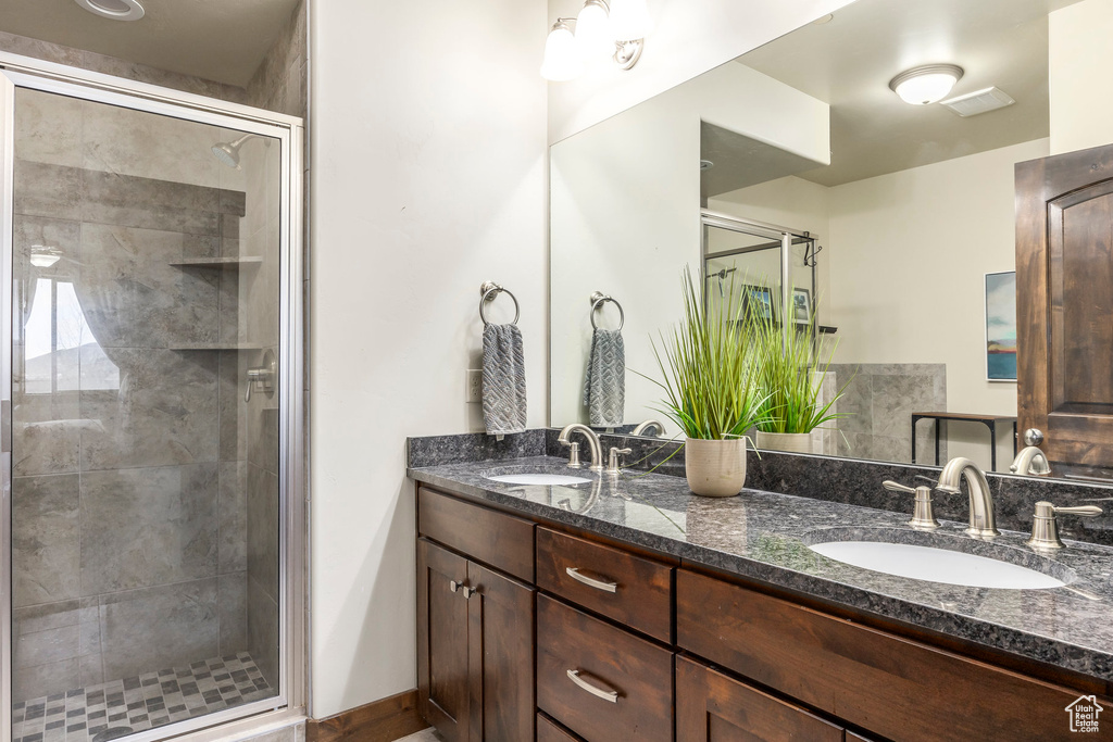 Bathroom featuring double vanity and a stall shower