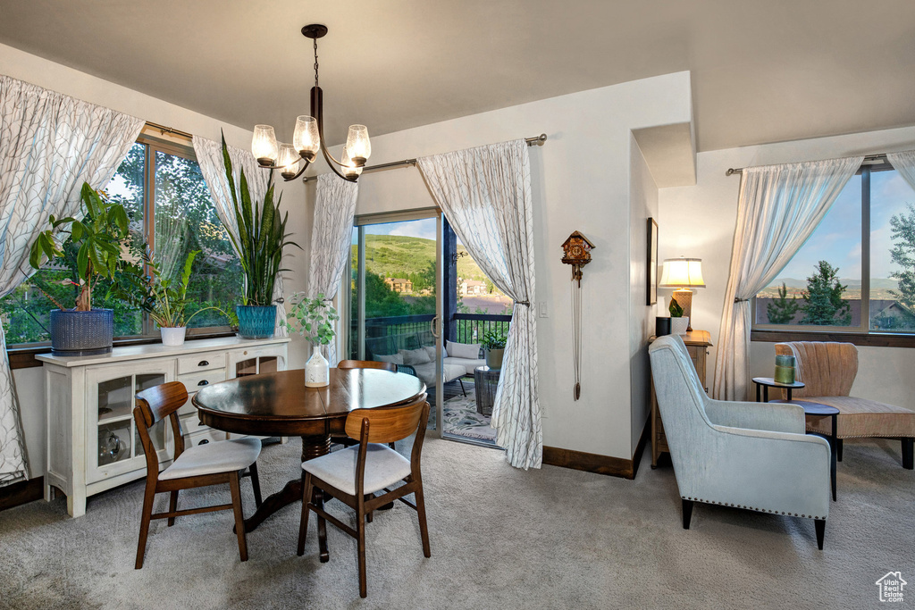 Dining area featuring a chandelier, light carpet, and healthy amount of natural light