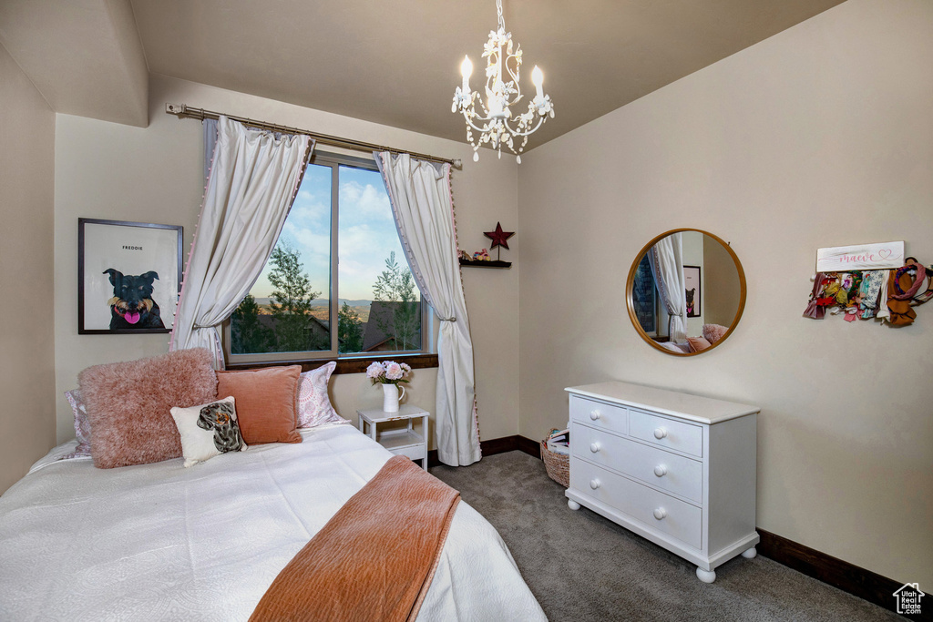 Bedroom with a chandelier and dark carpet