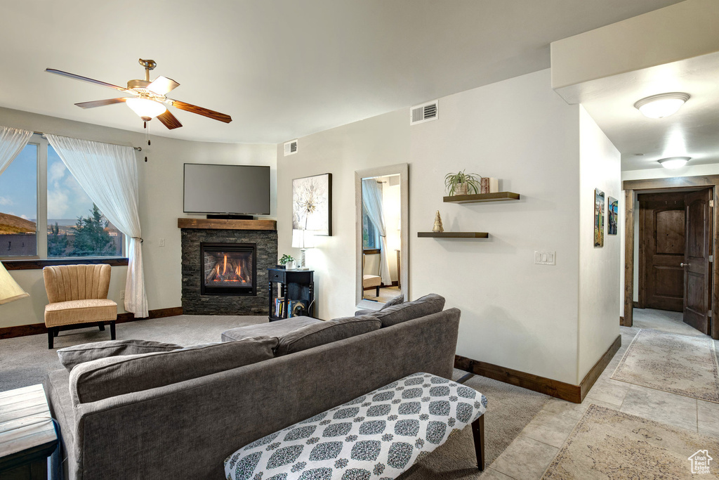 Living room with ceiling fan and a stone fireplace