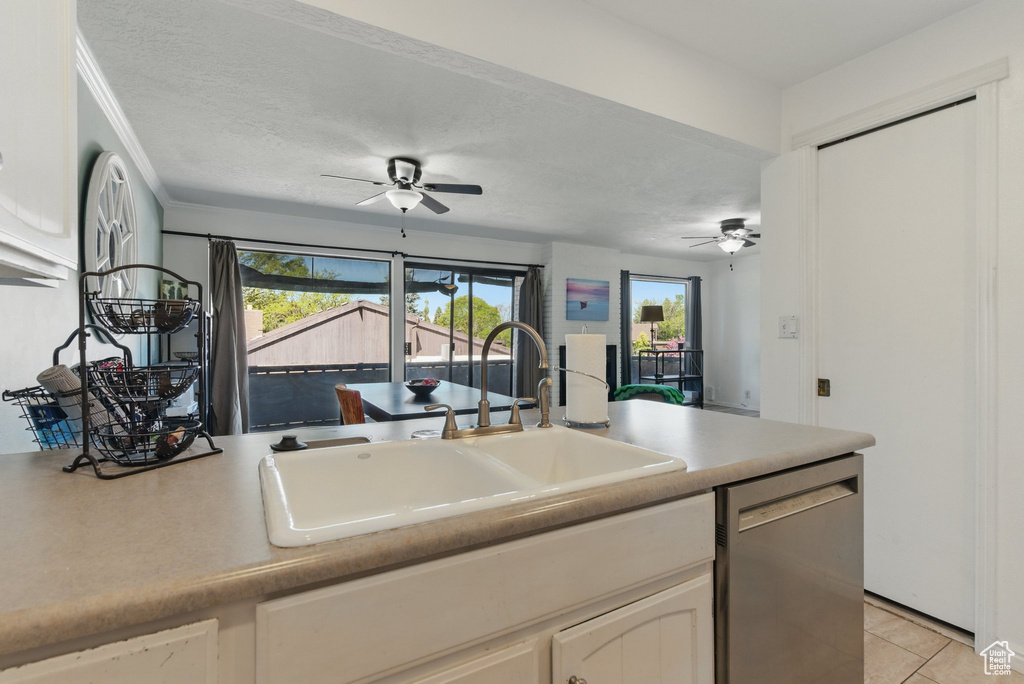 Kitchen with light tile patterned floors, ceiling fan, a sink, and dishwasher