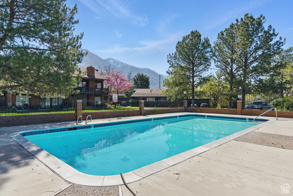 Community pool featuring fence and a mountain view