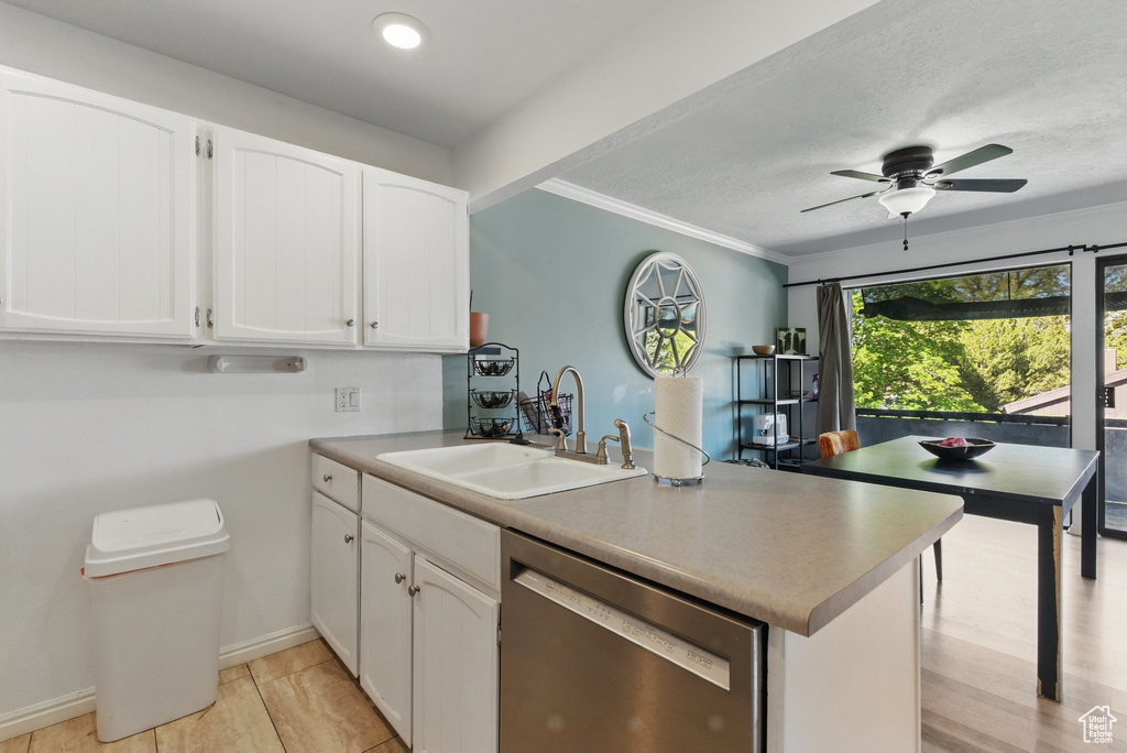 Kitchen with a sink, dishwasher, a peninsula, a ceiling fan, and white cabinetry