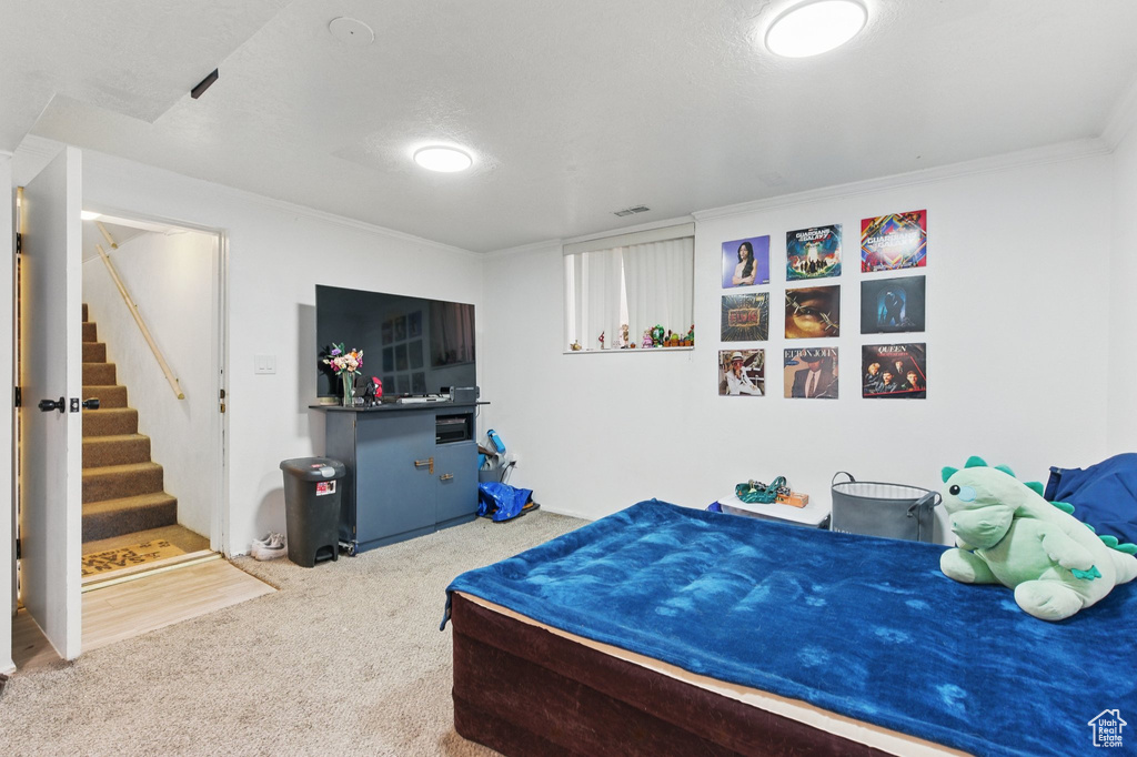 Carpeted bedroom with crown molding and visible vents
