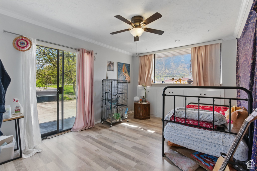 Bedroom with ornamental molding, wood finished floors, baseboards, access to outside, and a ceiling fan