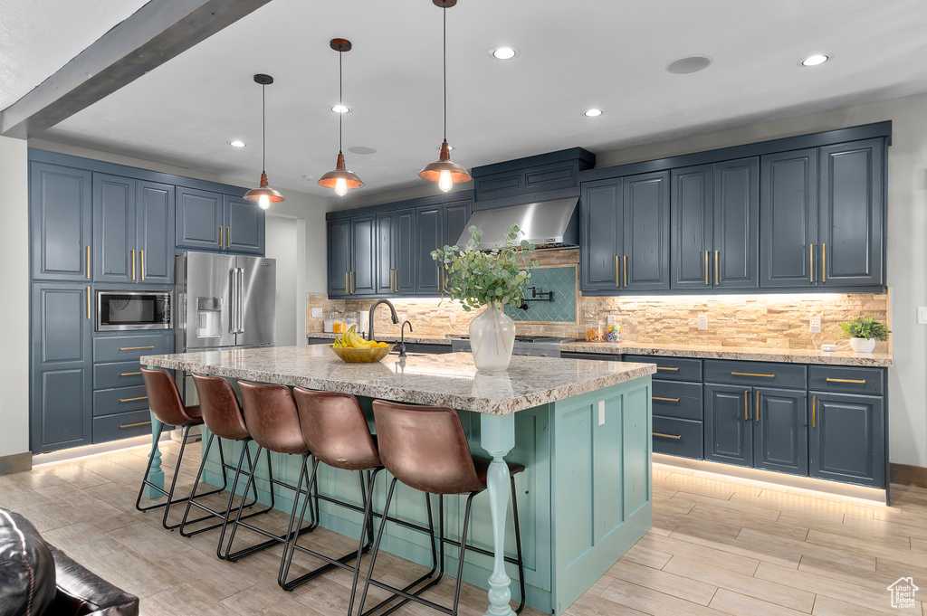 Kitchen featuring stainless steel appliances, recessed lighting, light wood-style floors, and tasteful backsplash