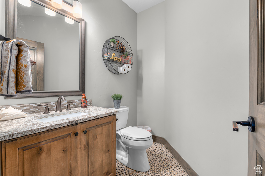 Half bathroom featuring vanity and toilet