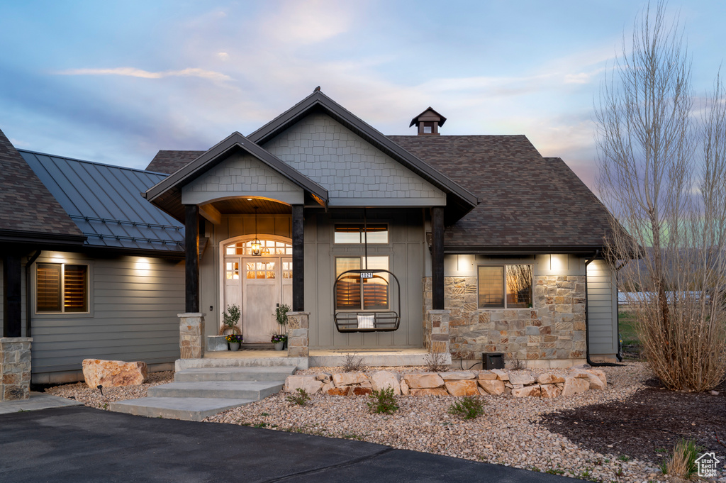 Craftsman-style home featuring stone siding, a standing seam roof, and metal roof