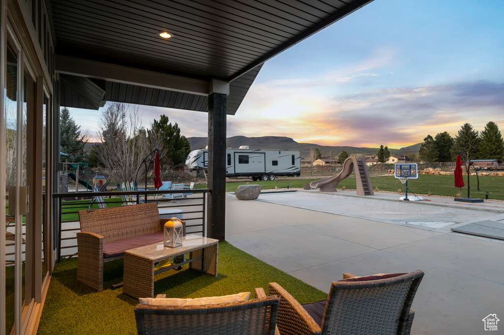 Patio terrace at dusk featuring a mountain view