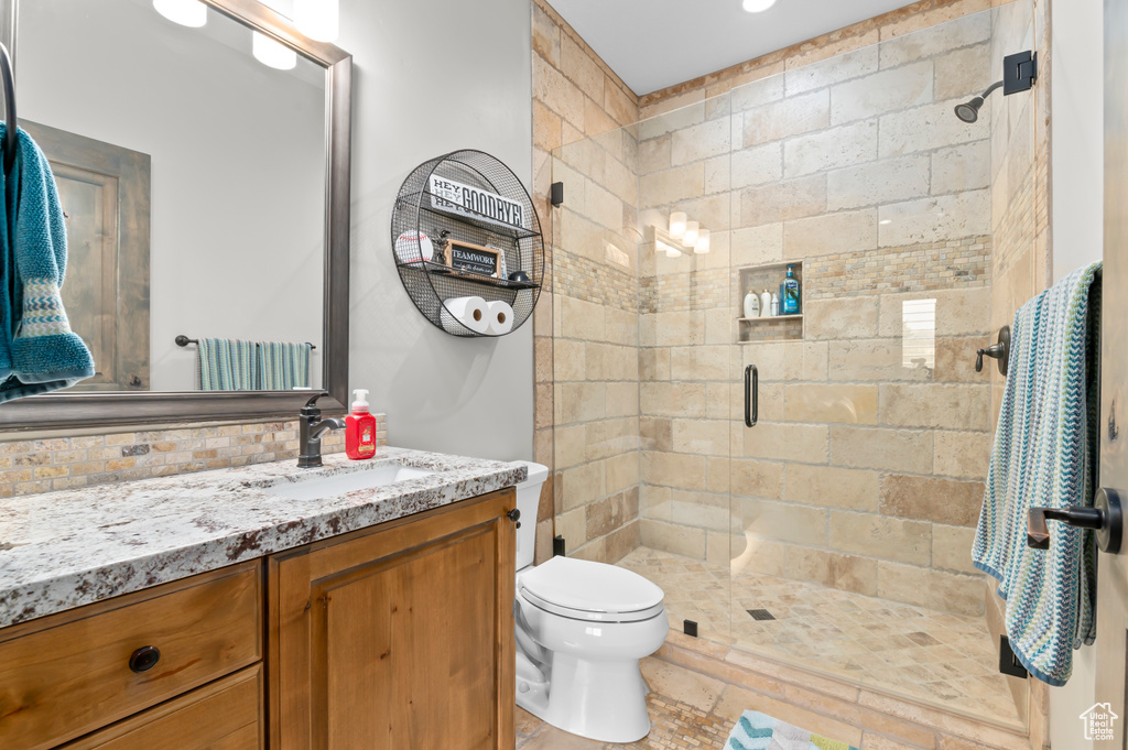 Bathroom with a shower stall, toilet, and vanity