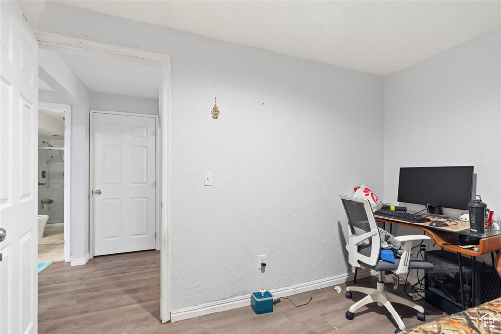 Home office with baseboards and wood finished floors