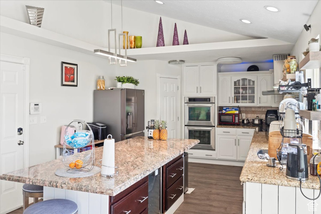 Kitchen with dark wood-style flooring, recessed lighting, appliances with stainless steel finishes, and decorative backsplash