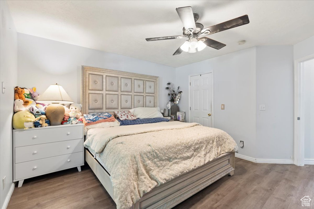 Bedroom with a ceiling fan, baseboards, and wood finished floors