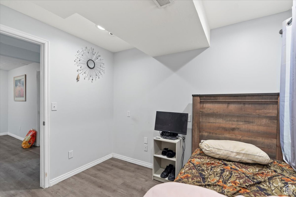 Bedroom with baseboards, wood finished floors, and visible vents