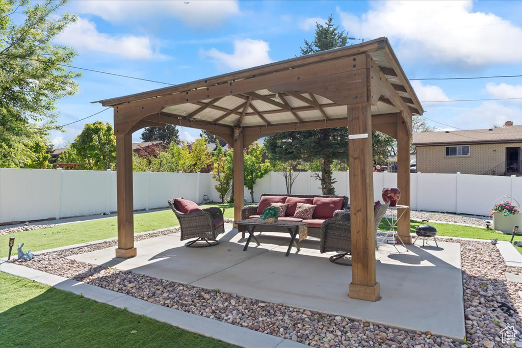 View of patio with a gazebo, an outdoor hangout area, and a fenced backyard