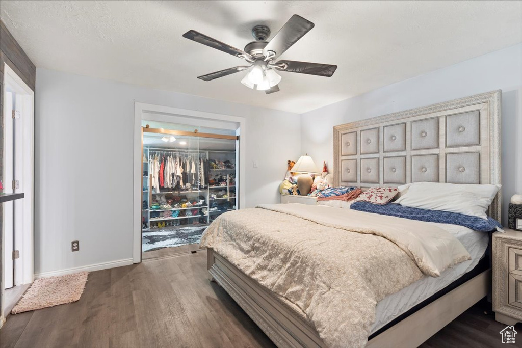 Bedroom with baseboards, dark wood finished floors, and ceiling fan