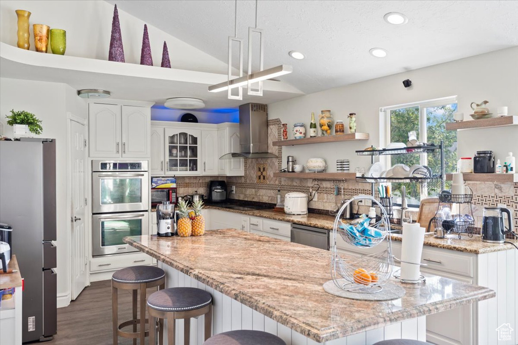 Kitchen with open shelves, backsplash, wall chimney range hood, and stainless steel appliances
