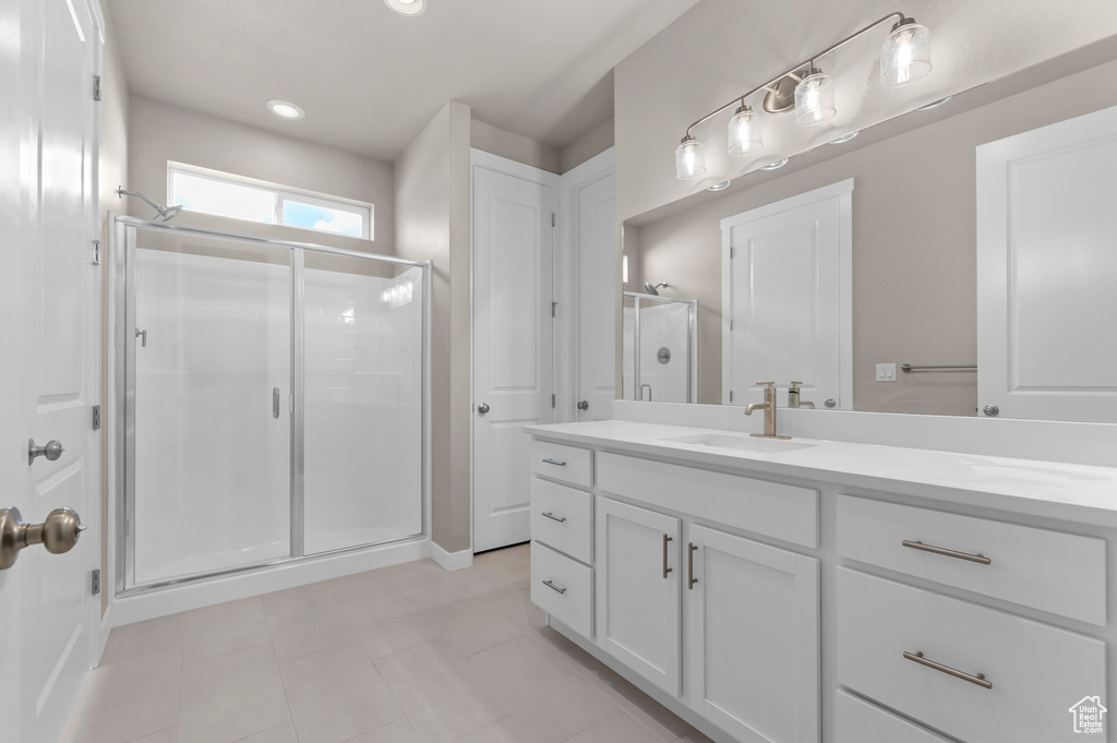 Bathroom featuring a shower stall, tile patterned floors, and vanity