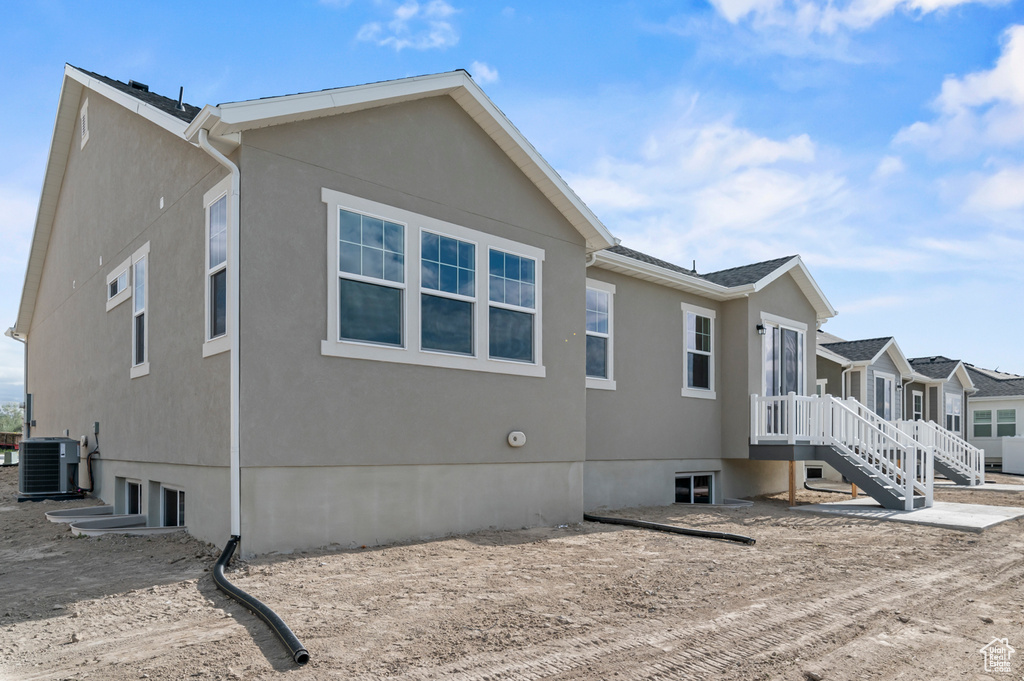 View of home's exterior with stucco siding and central AC