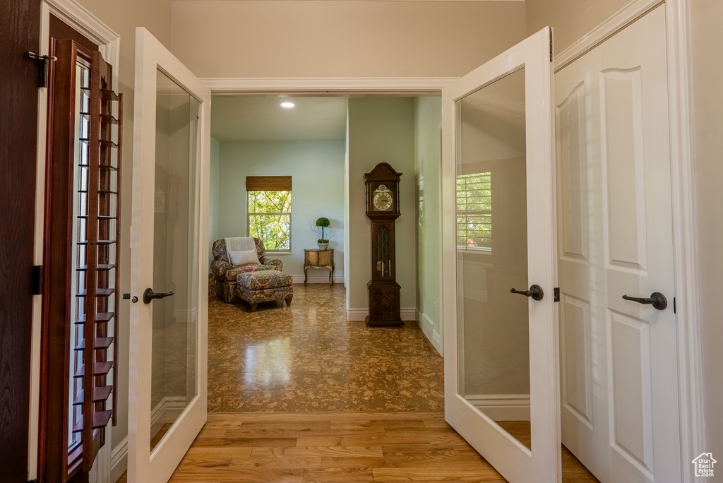 Hall featuring french doors, light wood-type flooring, and recessed lighting