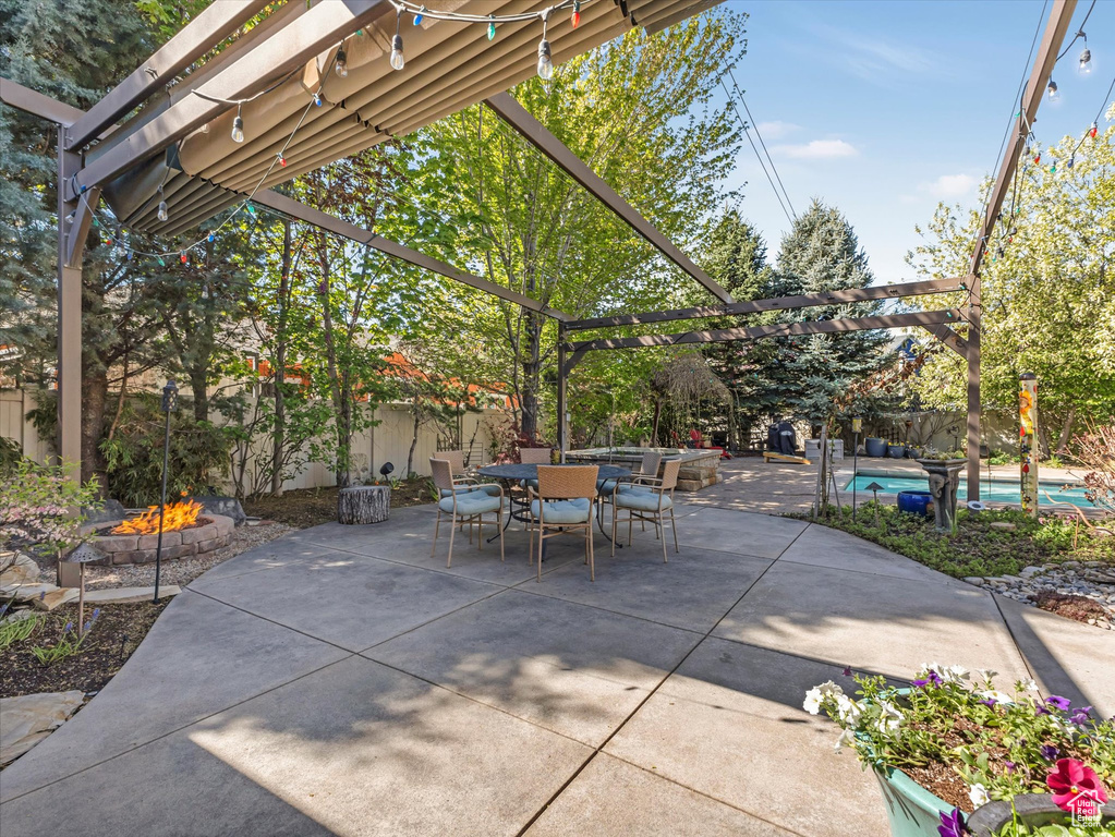 View of patio featuring an outdoor pool, an outdoor fire pit, and outdoor dining space
