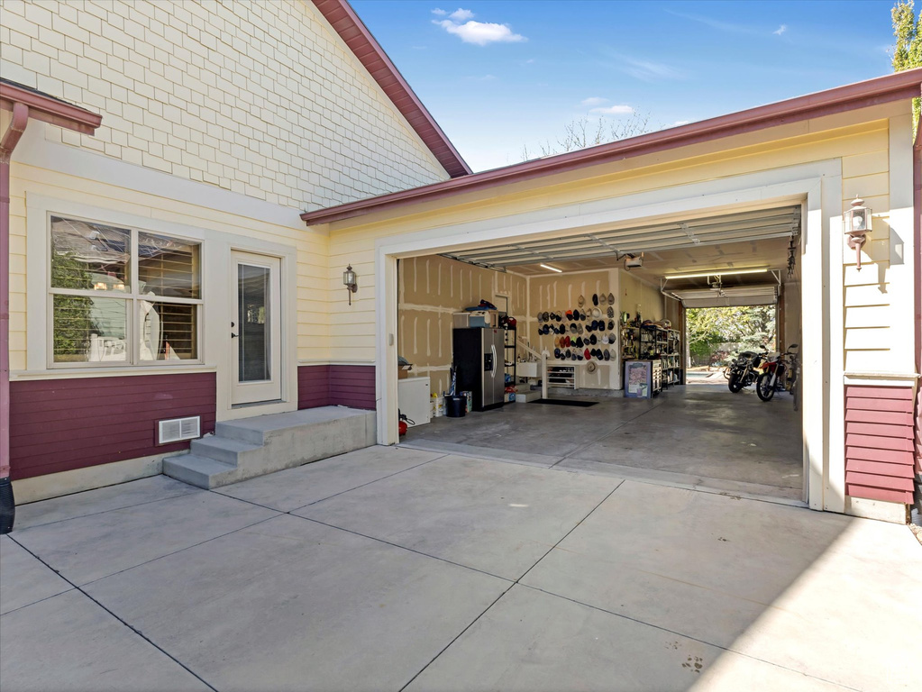Garage featuring visible vents and concrete driveway