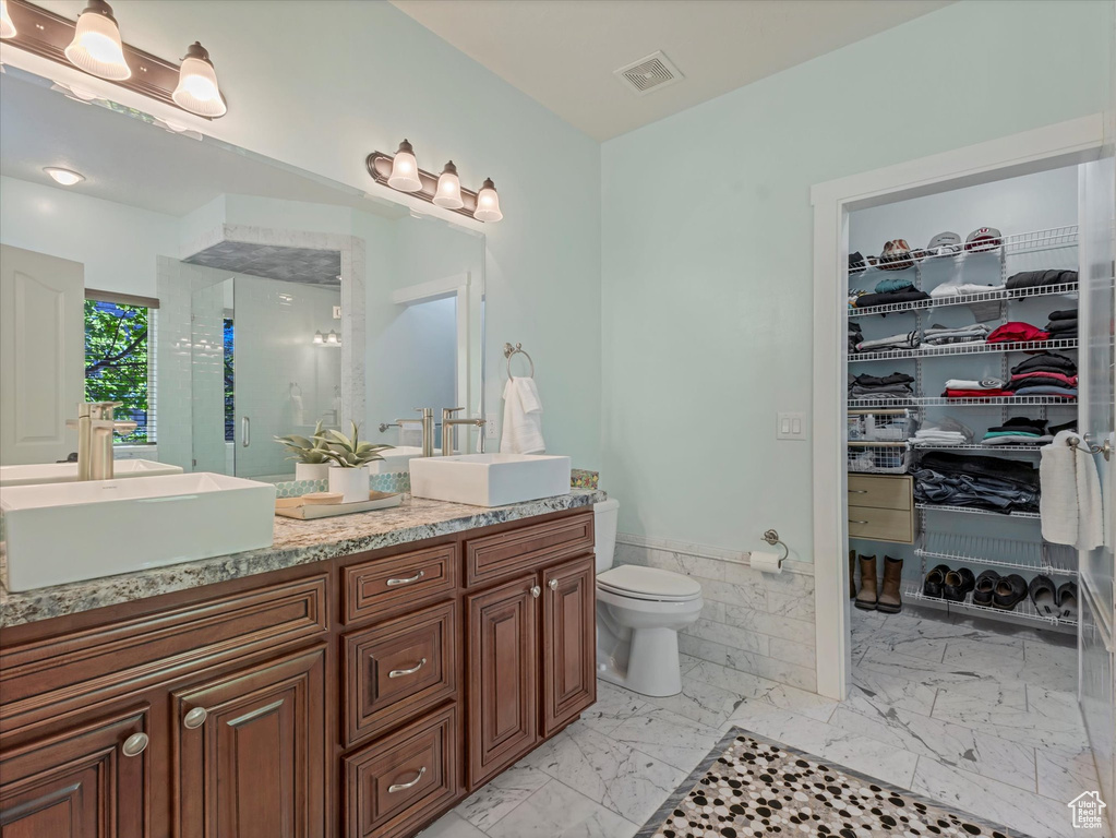 Bathroom with a sink, marble finish floor, double vanity, and visible vents