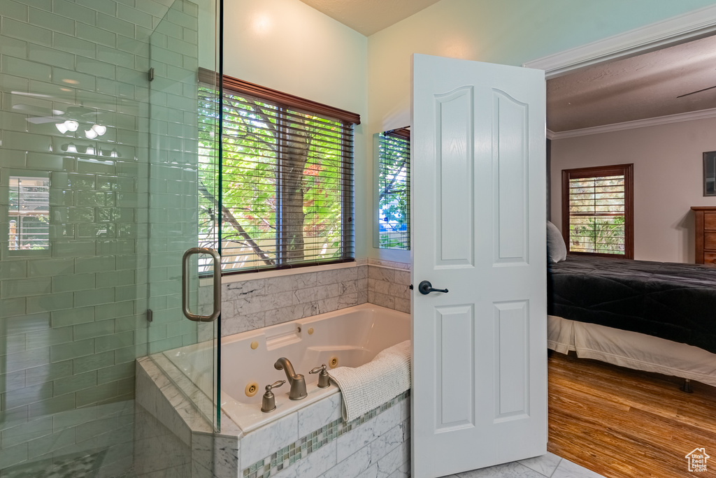 Full bathroom with a shower stall, a jetted tub, crown molding, and ensuite bath