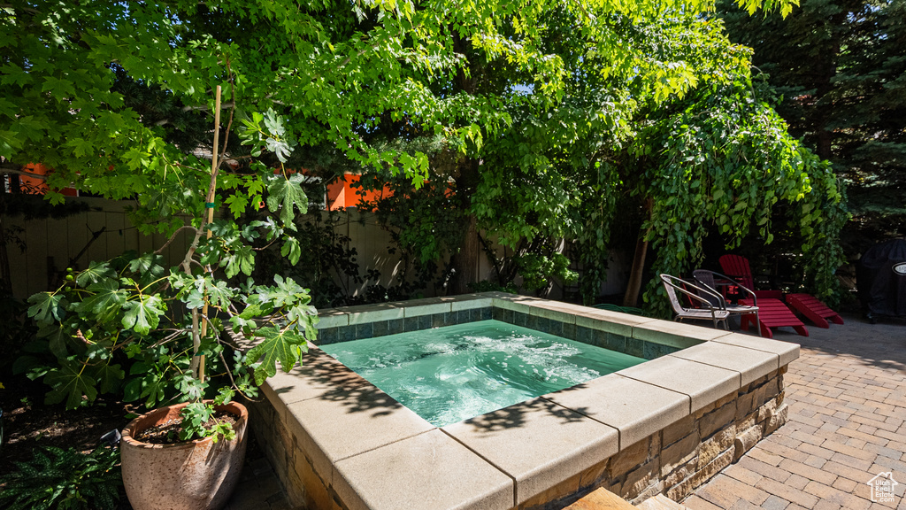 View of swimming pool featuring an in-ground hot tub, a fenced backyard, and a patio area