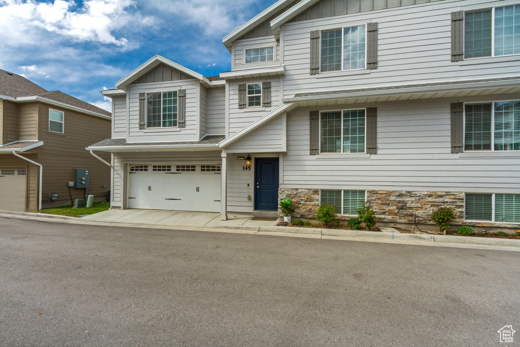 View of front facade with concrete driveway, an attached garage, and board and batten siding