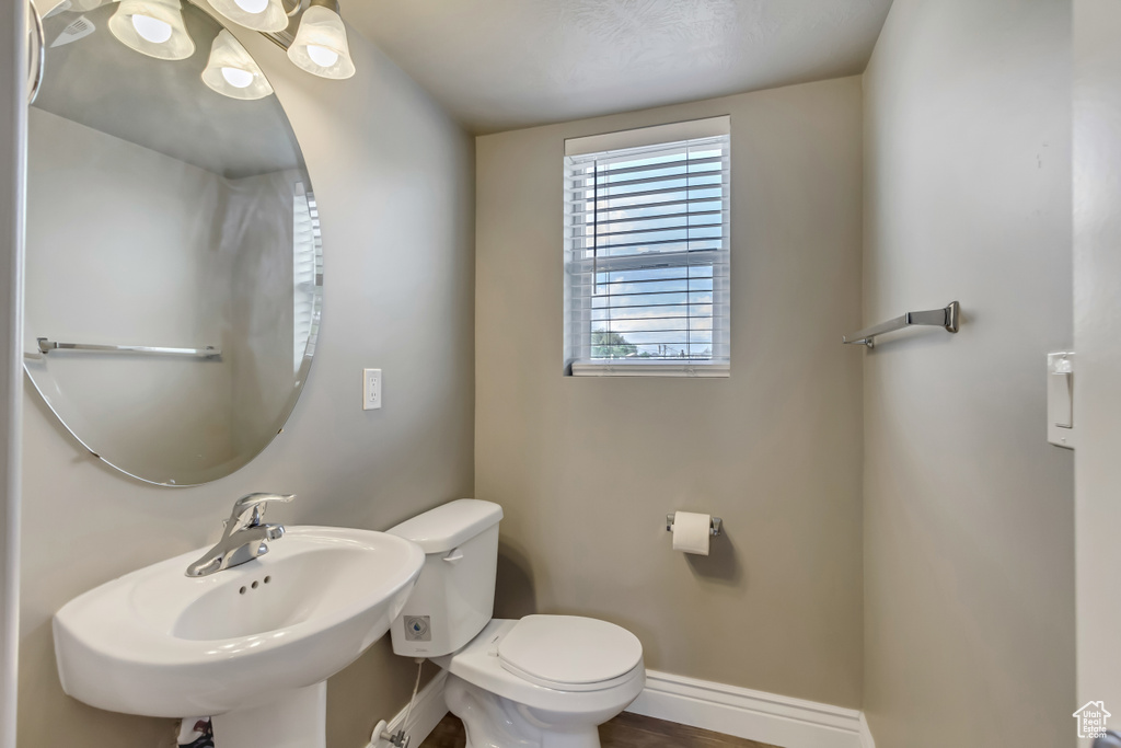 Bathroom with toilet, a sink, and baseboards