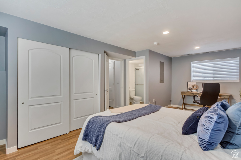Bedroom featuring light wood-style flooring, ensuite bathroom, a closet, baseboards, and recessed lighting