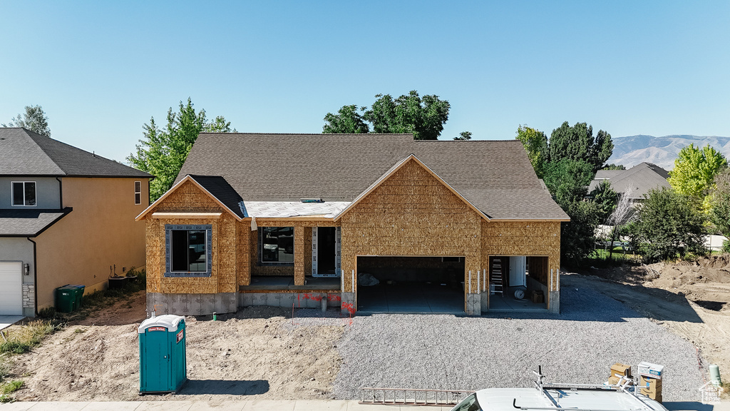 Property under construction with an attached garage, covered porch, and a mountain view