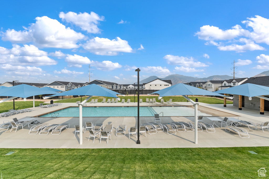 Community pool featuring a yard, a patio, and a residential view