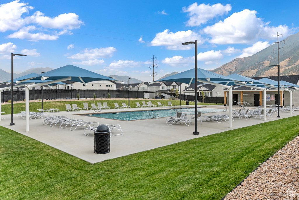 Pool with a patio, fence, a yard, and a residential view